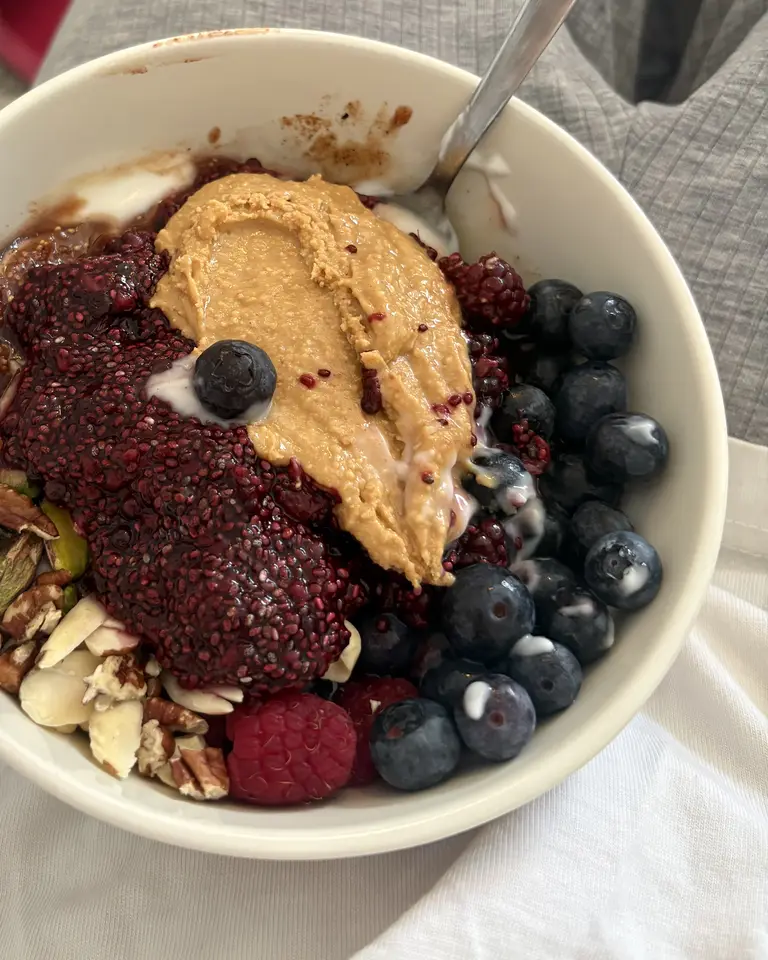 Santé Bowl with mixed berry chia pudding, almond butter, blueberries, a raspberry, sliced almonds and pecans